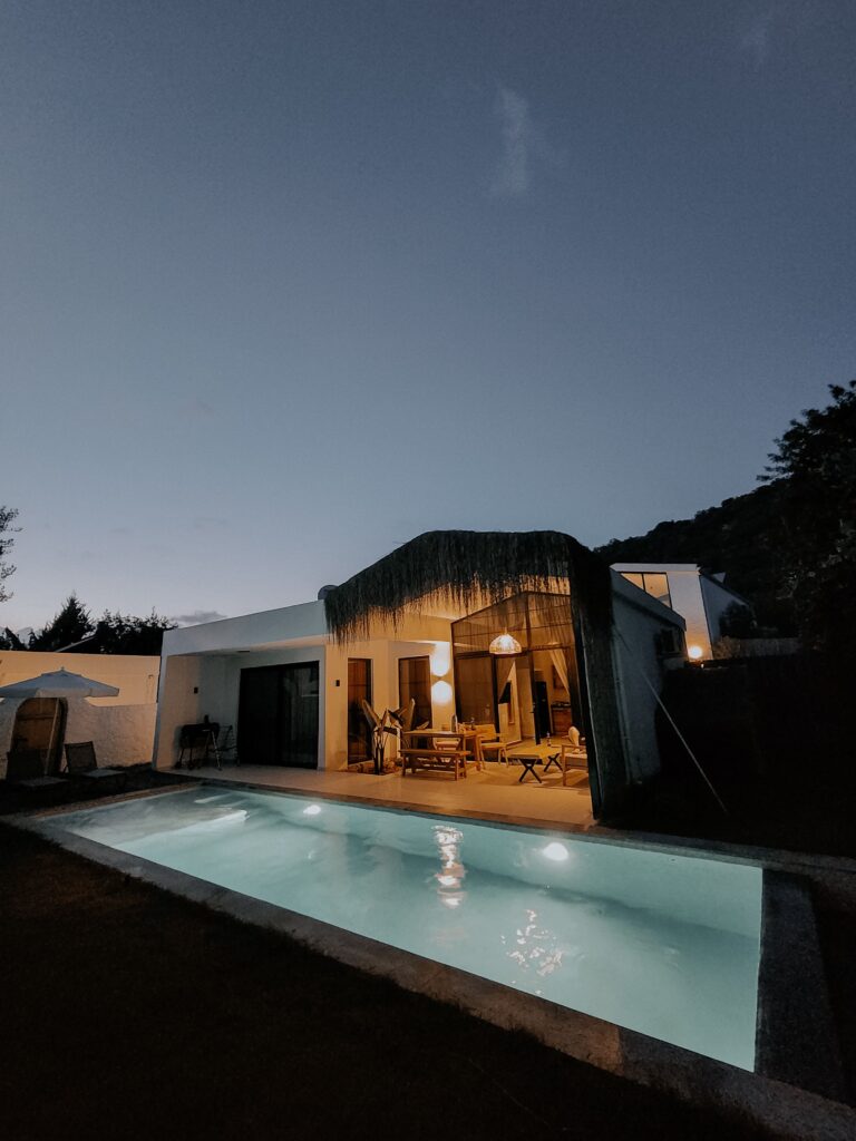 Beautiful villa with pool illuminated at twilight in Kayaköy, Türkiye, offering a serene vacation spot.